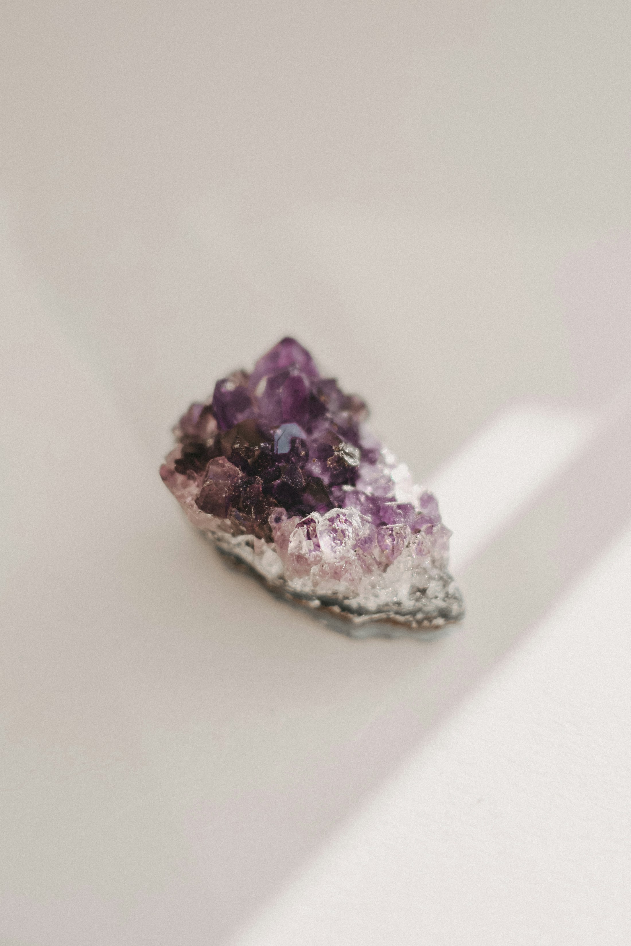 A single amethyst crystal cluster resting in soft natural light
