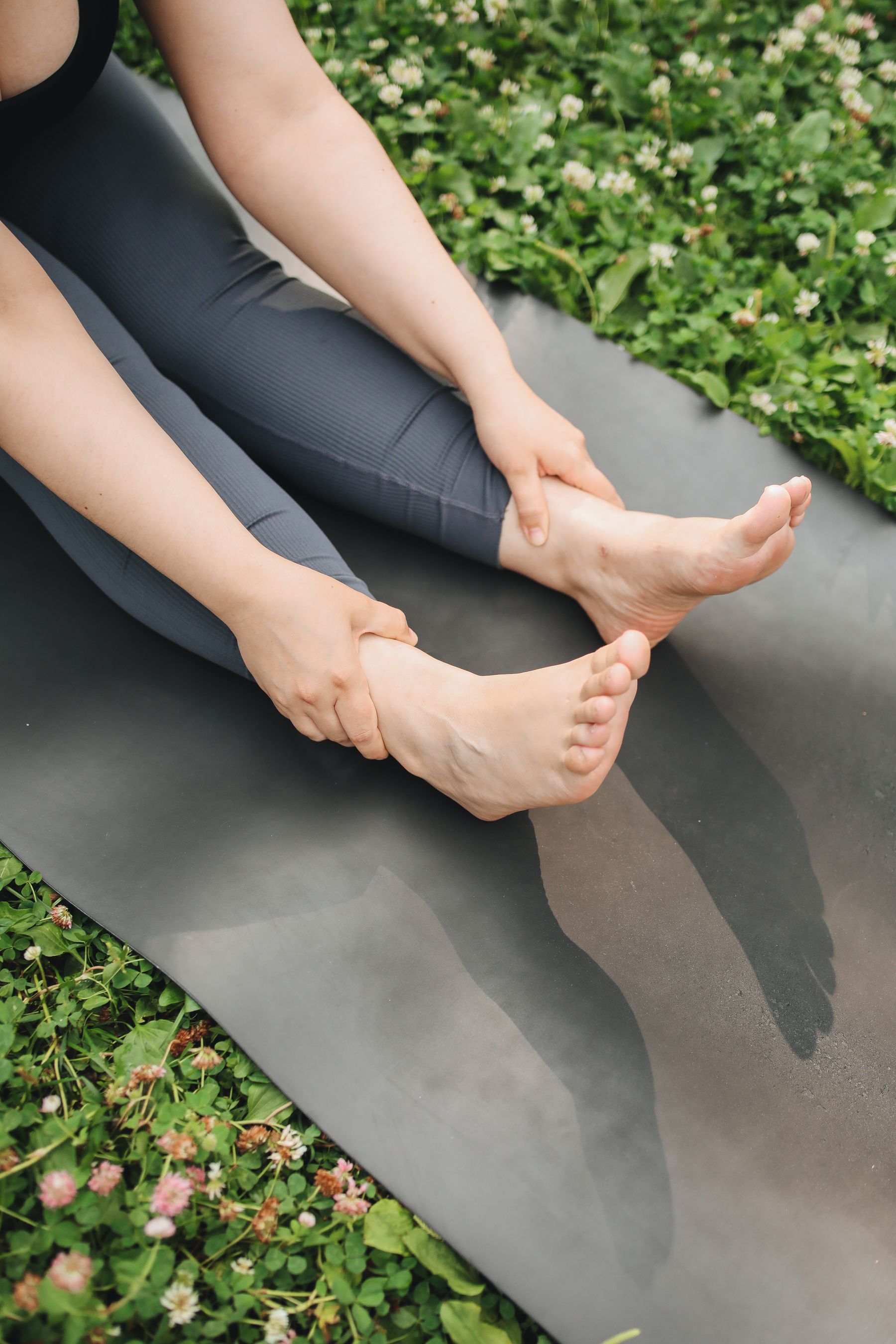 A gentle forward-fold stretch in soft, warm light